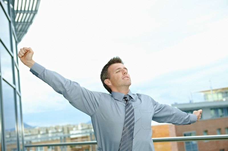 Man stretching on a balcony outside the office