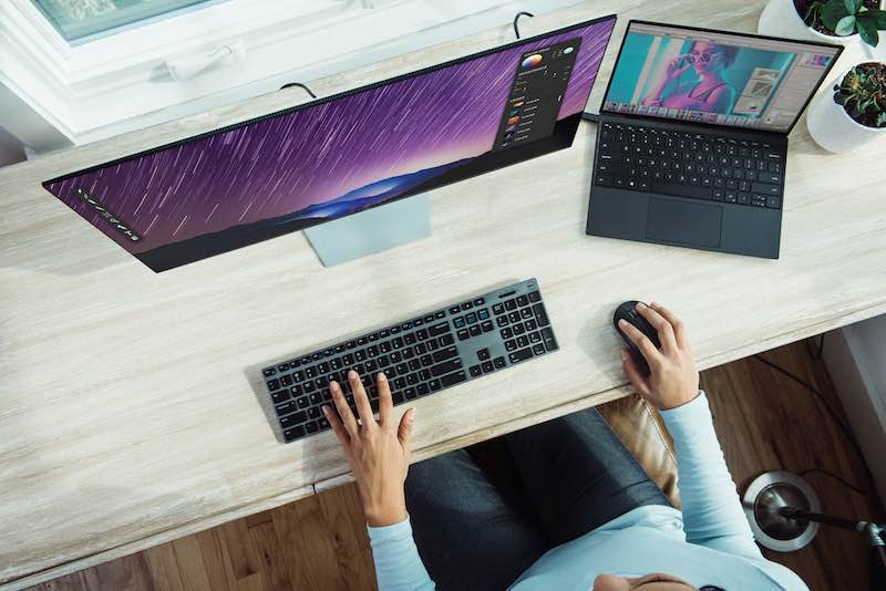 Work from home, home office desk with laptop and LCD monitor in front of the window